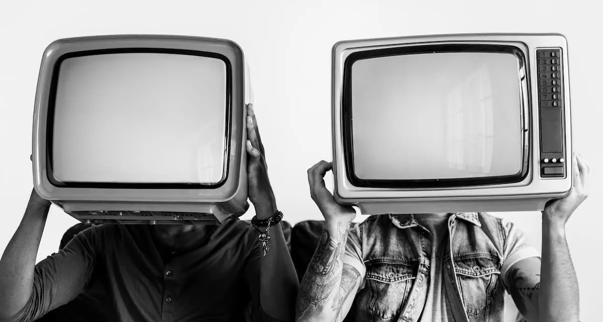 gente que sostiene la television retro junto la otra