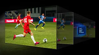 Jugadores de fútbol en un campo verde, uno con uniforme rojo y otro azul, jugando cerca de una portería.