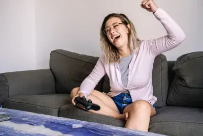 Mujer sentada en el sofá jugando a videojuegos