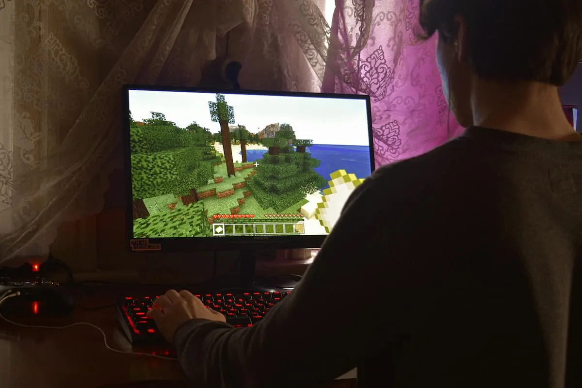 Persona jugando a Minecraft en un ordenador de escritorio.