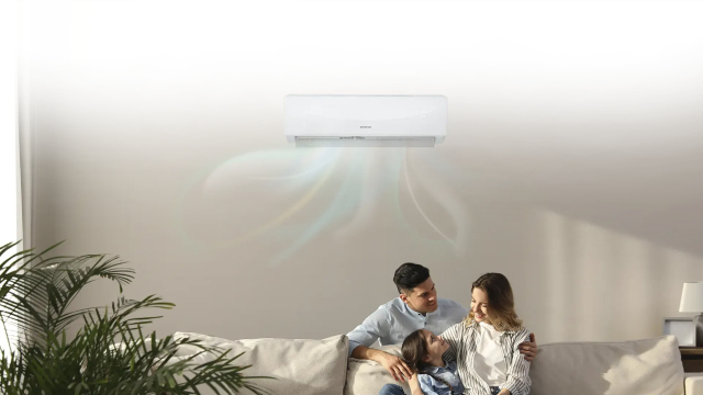 Familia sentada en un sofá con el aire acondicionado encima.