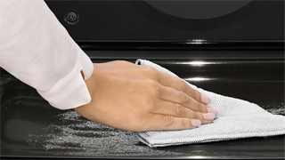 Detalle de una mano retirando con un paño las cenizas resultantes de la pirólisis