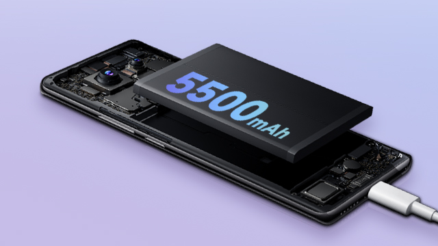 Teléfono negro abierto con batería de 5500mAh y cable blanco conectado. Fondo morado claro.
