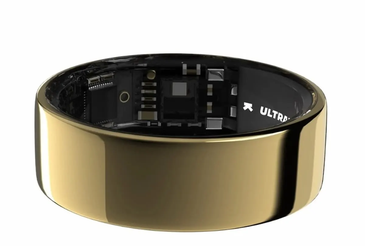 Anillo inteligente dorado con interior negro y sensores electrónicos visibles.