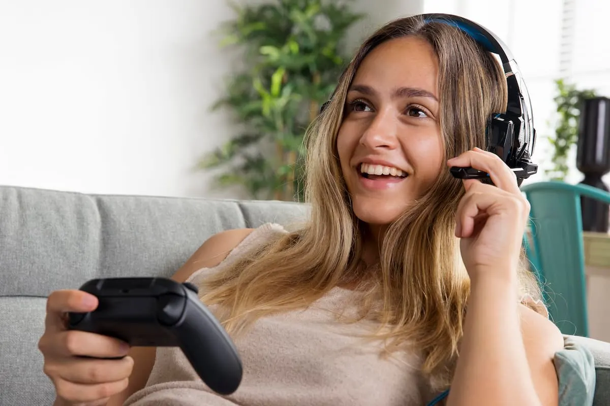 Persona jugando con mando y auriculares inalámbricos.
