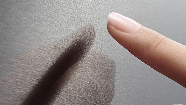 Detalle de un dedo tras tocar la superficie  de acero inoxidable antihuellas de la puerta