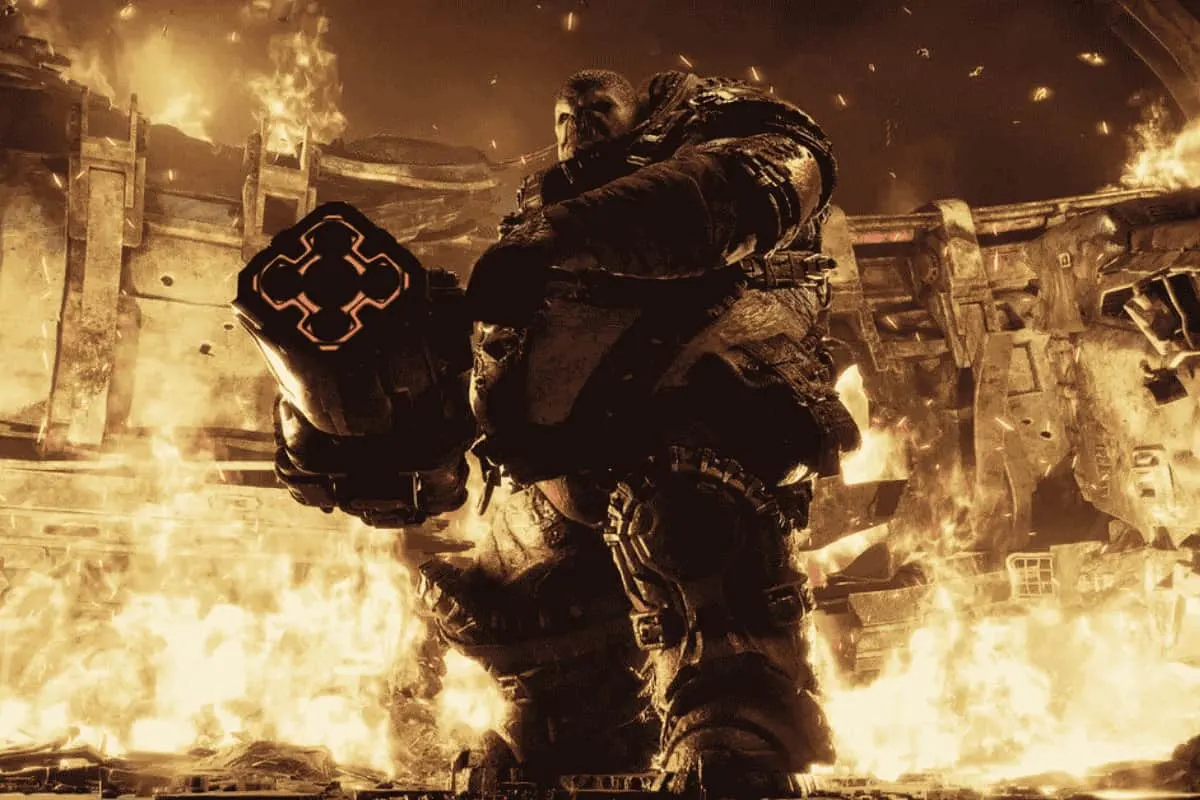 Soldado con armadura pesada y arma futurista rodeado de fuego y explosiones en Gears of War