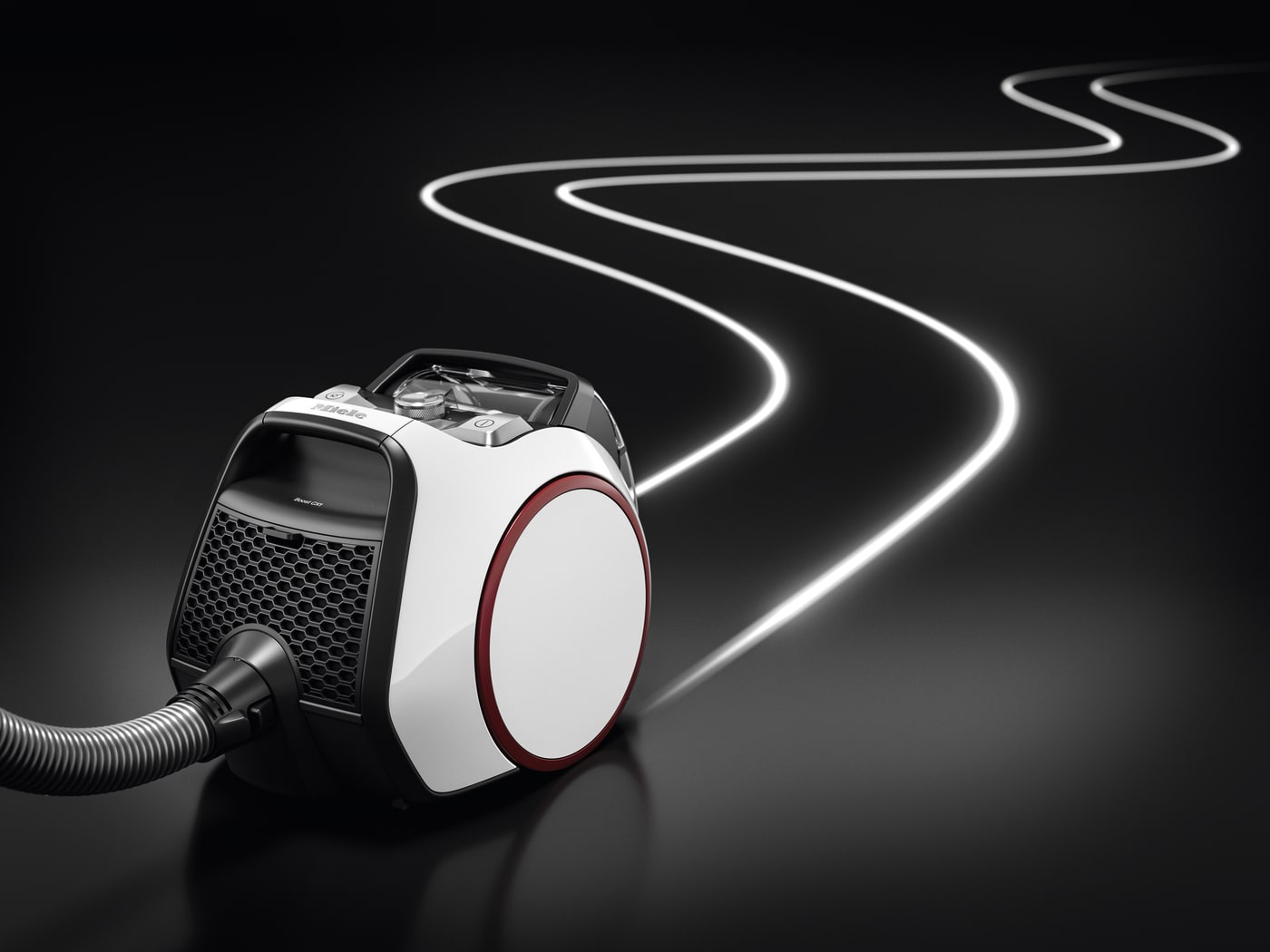 Aspiradora blanca y negra sobre superficie negra con camino blanco ondulado al fondo.