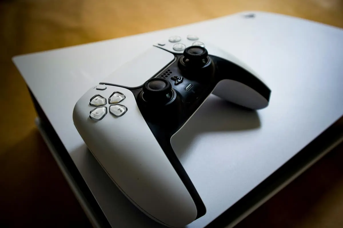 Consola PlayStation 5 con mando DualSense encima.