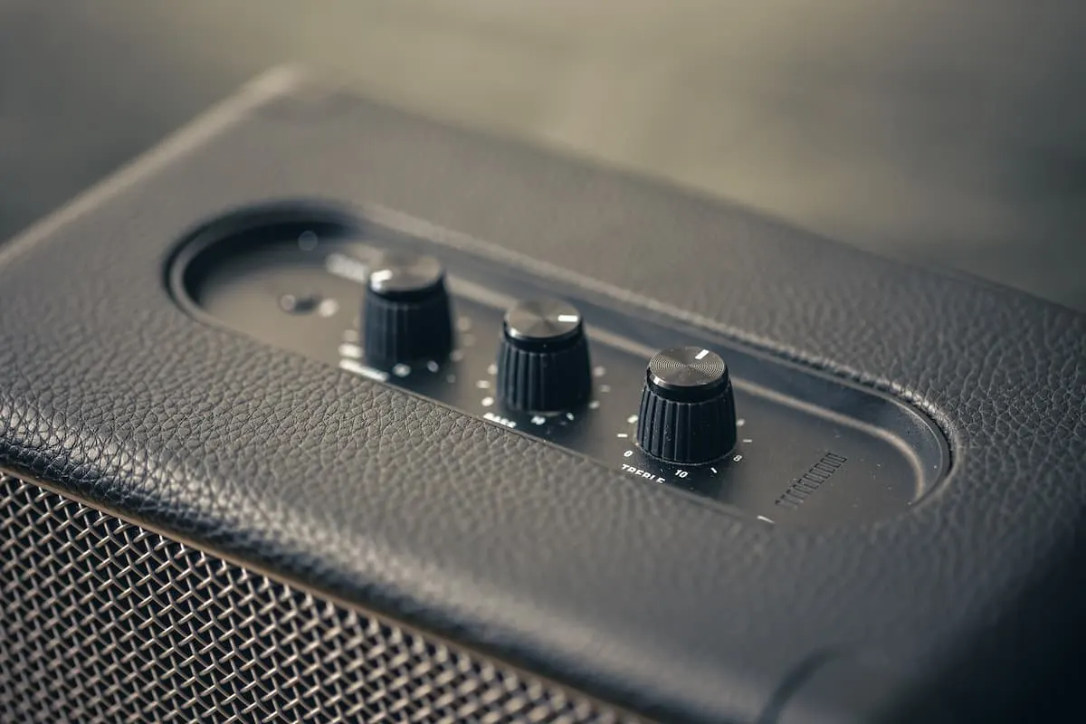 Primer plano de la parte superior de un altavoz negro con tres perillas de control.