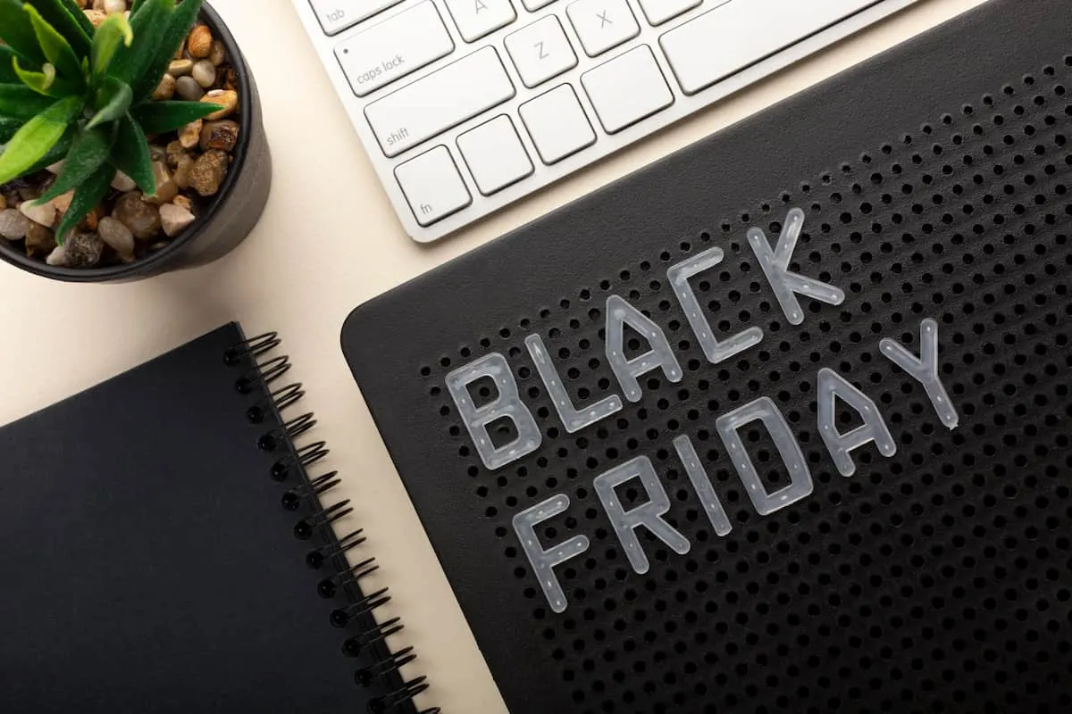 Letras de Black Friday junto a teclado, libreta y planta.