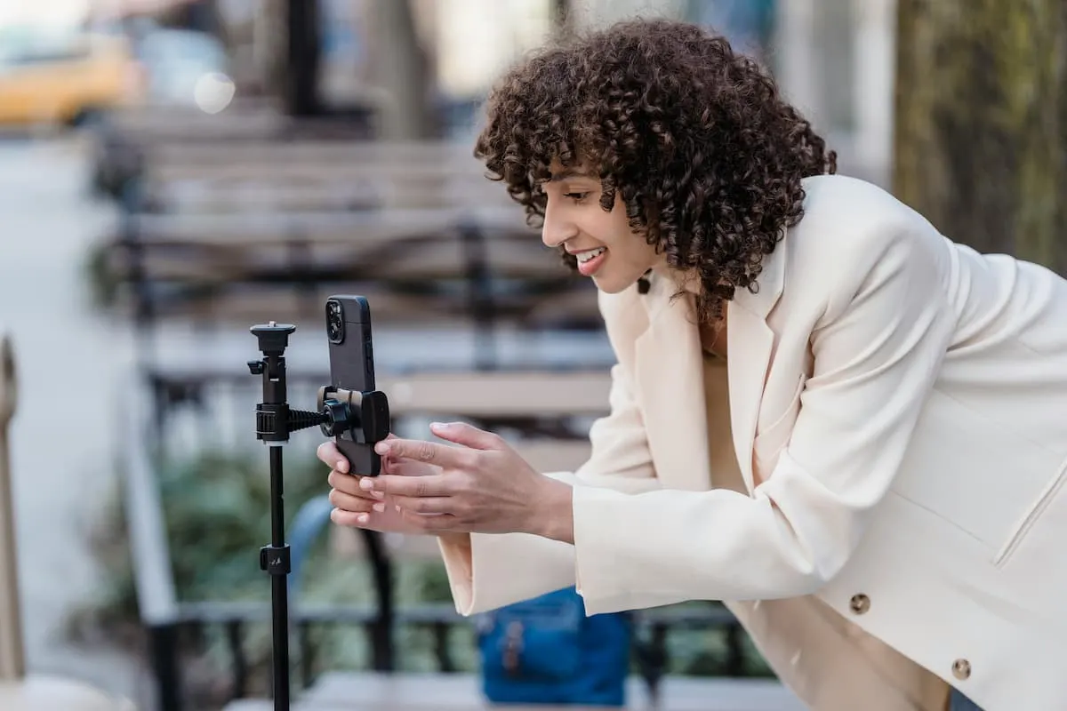Mujer ajustando un smartphone en un trípode.