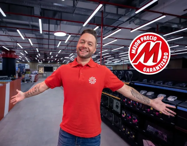 Un hombre en camisa roja y jeans está parado en una tienda, con los brazos extendidos, junto a estanterías negras. Un logo rojo y blanco está a la derecha.
