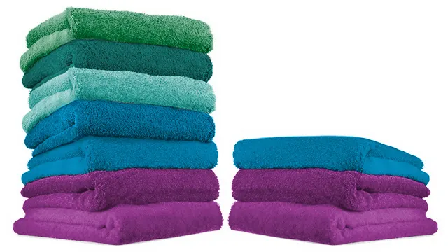 Dos pilas de toallas de colores limpias y secas, una con siete prendas y otra con tres