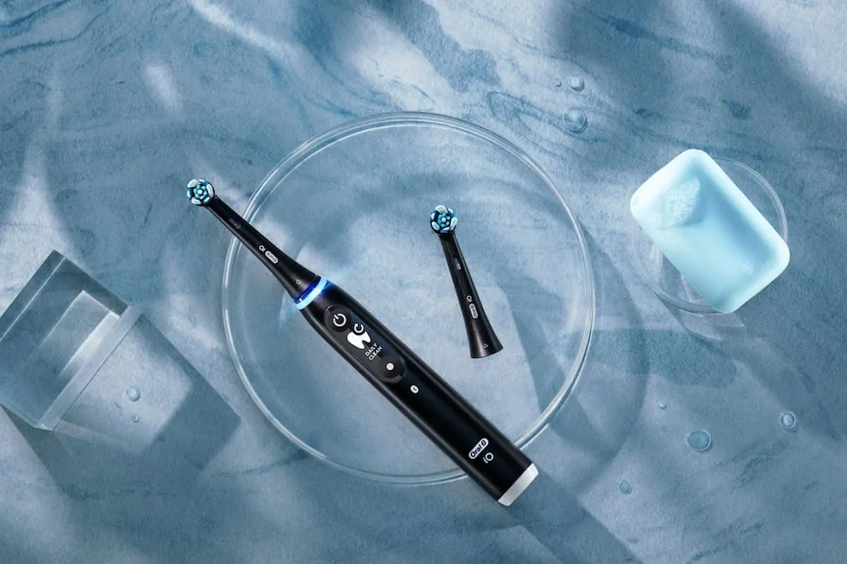 Cepillo de dientes eléctrico Oral-B iO negro sobre superficie azul.