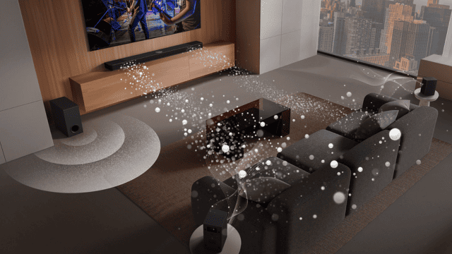 Salón con TV, barra de sonido, subwoofer y sofá grises. Círculos blancos representan sonido envolvente. Ventana con vista urbana.