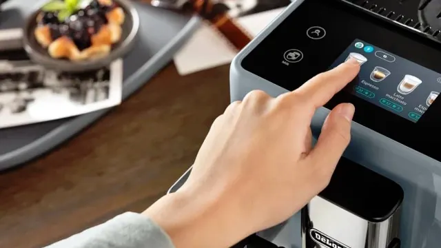 Mano presionando con el dedo índice la pantalla táctil de cafetera.