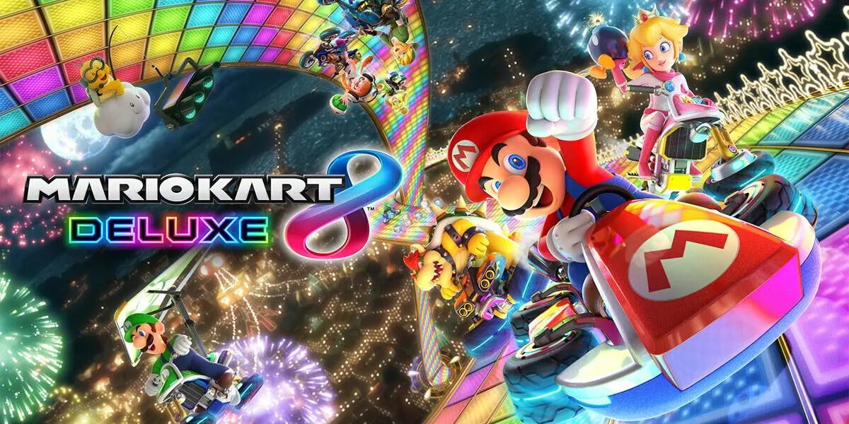 Mario y otros personajes compiten en karts en una pista colorida, con fuegos artificiales de fondo y el logo de Mario Kart Deluxe.