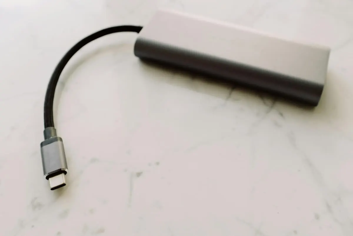 Adaptador OTG USB-C tipo hub sobre una superficie blanca.