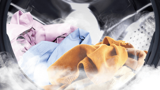 Ropa de colores dentro del tambor de la lavadora con vapor visible.