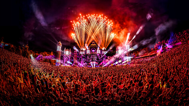 Imagen del festival de Tomorrowland de noche en el escenario principal con todos los participantes y fuegos artificiales