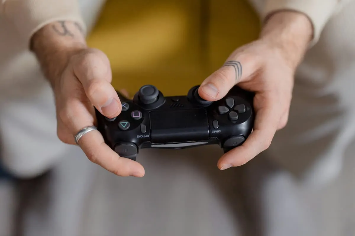 Persona sujetando un mando de PlayStation.