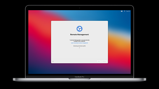 Un portátil plateado muestra una ventana de gestión remota sobre un fondo colorido. La ventana tiene un icono azul de engranaje.