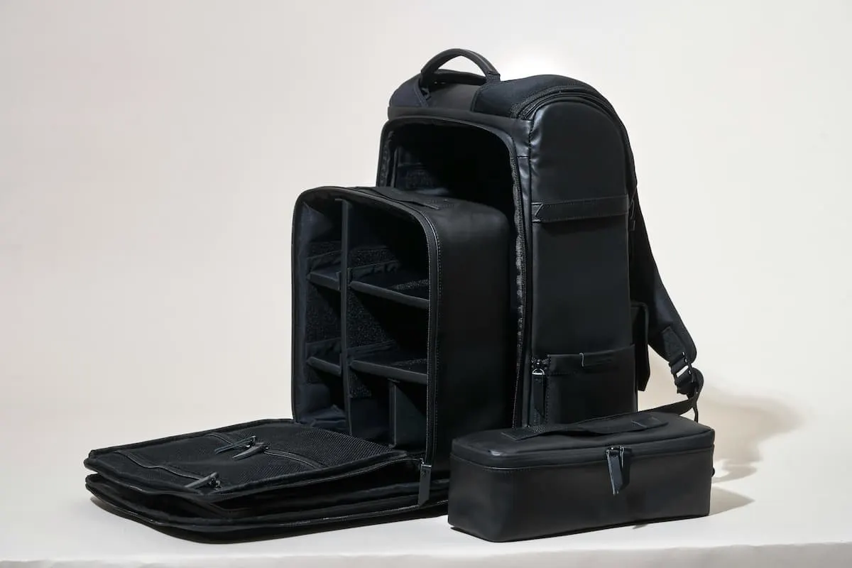 Mochila negra abierta con compartimentos organizadores.