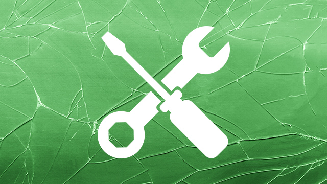 Sobre un fondo verde agrietado, una llave inglesa y un destornillador blancos se cruzan, simbolizando herramientas o reparación.