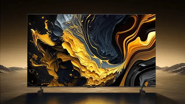 Una televisión muestra arte abstracto dorado, negro y gris. De fondo, un paisaje montañoso marrón.