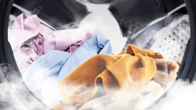 Ropa de colores dentro del tambor de la lavadora con vapor visible.