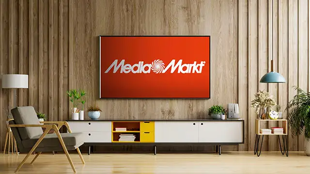 Salón con pared de madera vertical, TV con logo MediaMarkt, mueble bajo blanco y amarillo, sillón y lámpara colgante.