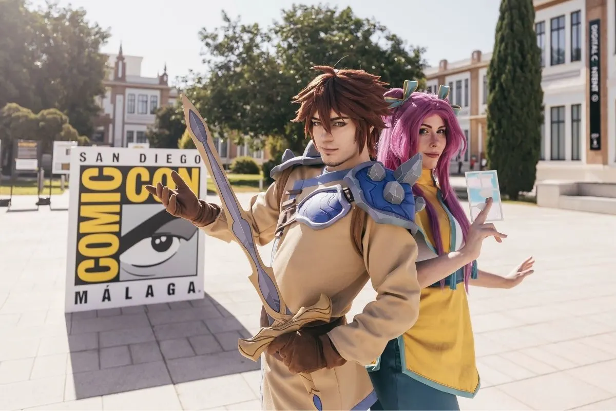 Cosplayers posando junto al cartel de Comic-Con Málaga