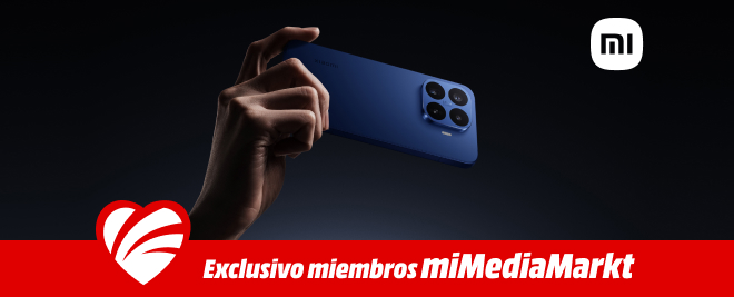 Mano sosteniendo smartphone Xiaomi azul, logo mi, banner rojo con corazón blanco y texto Exclusivo miembros miMediaMarkt sobre fondo negro.