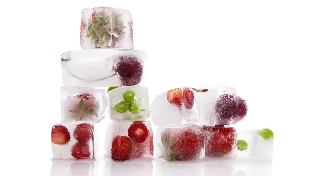 Cubitos de hielo apilados con frutas congeladas en su interior