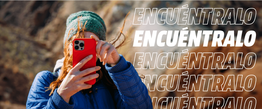 Mujer con gorro verde y chaqueta azul sosteniendo un móvil rojo. Texto superpuesto dice "ENCUENTRALO" sobre un fondo natural difuminado.