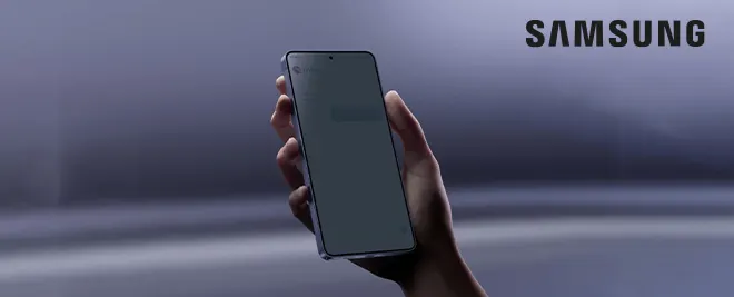 Mano sosteniendo un smartphone Samsung sobre fondo oscuro con el logo Samsung en la esquina superior derecha