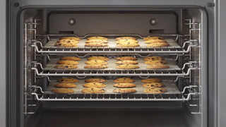 Detalle del interior del horno con una hornada de galletas colocada en tres alturas