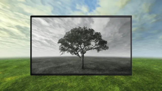 Monitor negro muestra árbol en blanco y negro sobre hierba verde y cielo nublado.