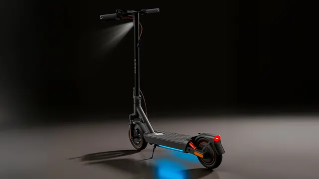 Xiaomi Electric Scooter 5 Max encendido, mostrando luz frontal blanca y luz trasera roja en un entorno oscuro.