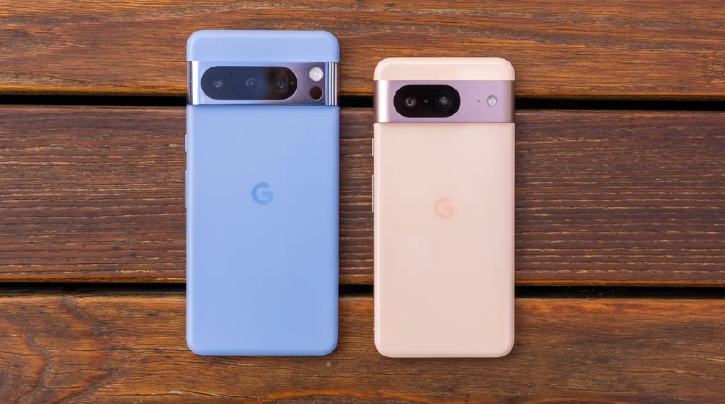 Dos teléfonos móviles, uno azul y otro color crema, están sobre una superficie de madera marrón. Ambos tienen la letra G en el centro.