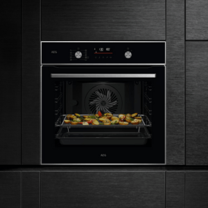 Imagen de un horno con una bandeja de comida dentro con la marca AEG