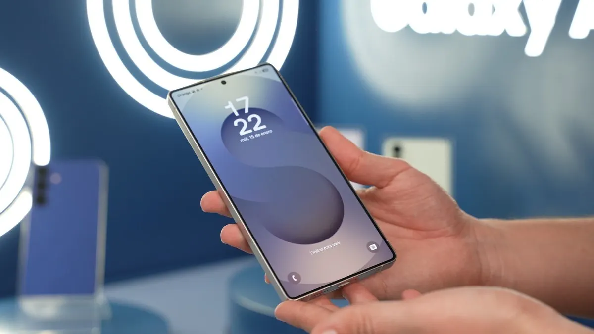 Unas manos sostienen un teléfono con fecha y hora en la pantalla. El fondo es azul con luces blancas y un texto que dice Galaxy A.