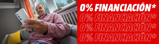 Hombre sentado en sofá sostiene un móvil hacia la cámara, en salón luminoso, con franja roja "0% Financiación