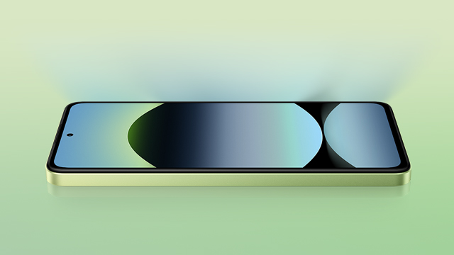 Un teléfono celular horizontal con pantalla azul, verde y negra sobre una superficie verde clara.