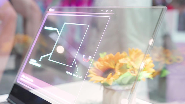 Un portátil transparente muestra un diagrama lineal sobre un jarrón con girasoles amarillos y verdes.