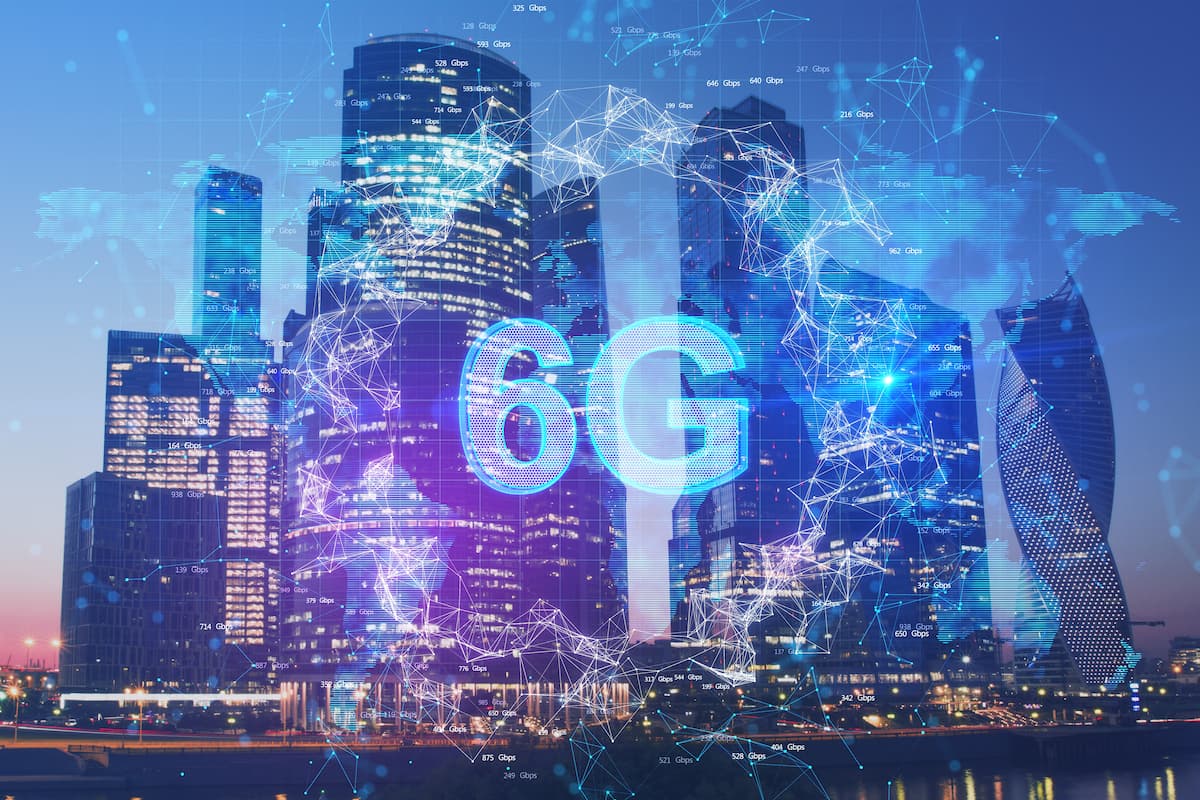 Ciudad con rascacielos al atardecer, con el texto “6G” sobreimpreso y rodeado de conexiones digitales azules.