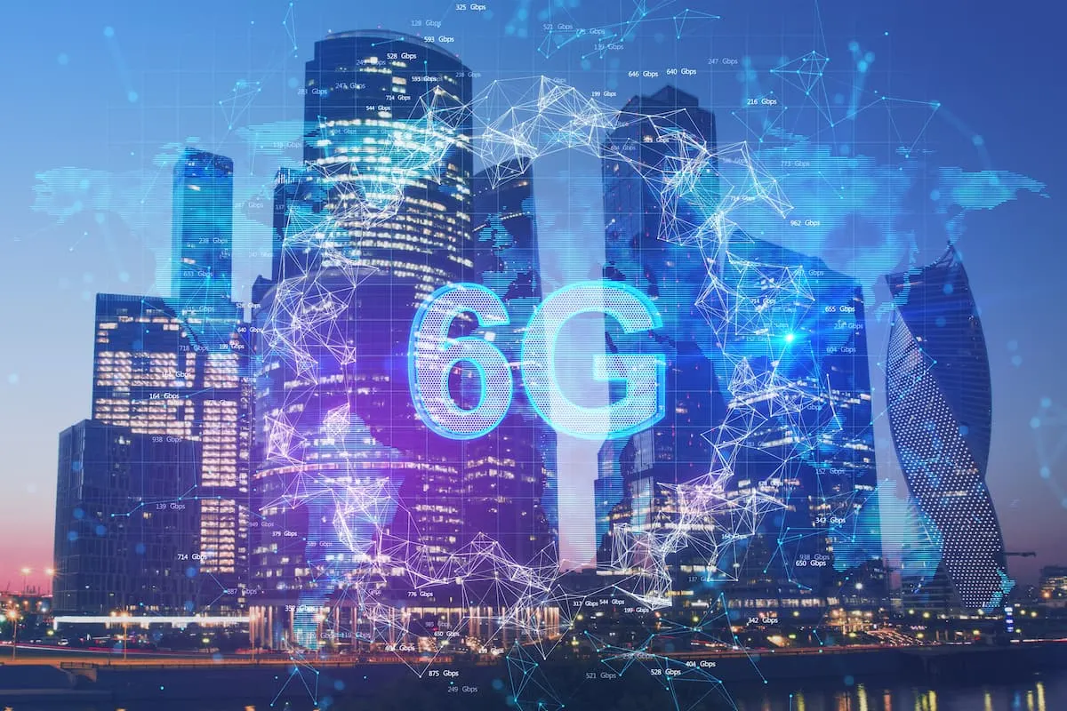 Ciudad con rascacielos al atardecer, con el texto “6G” sobreimpreso y rodeado de conexiones digitales azules.