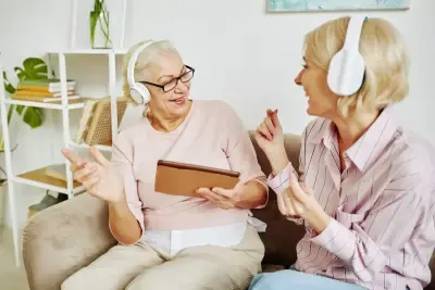 Dos mujeres con cascos blancos inalámbricos escuchando música