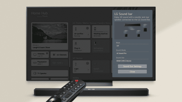 Televisor muestra la interfaz de LG Home Hub con menú de barra de sonido LG y control remoto encima de la barra de sonido.